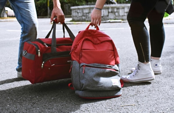 Personnes prenant des bagages rouges du sol
