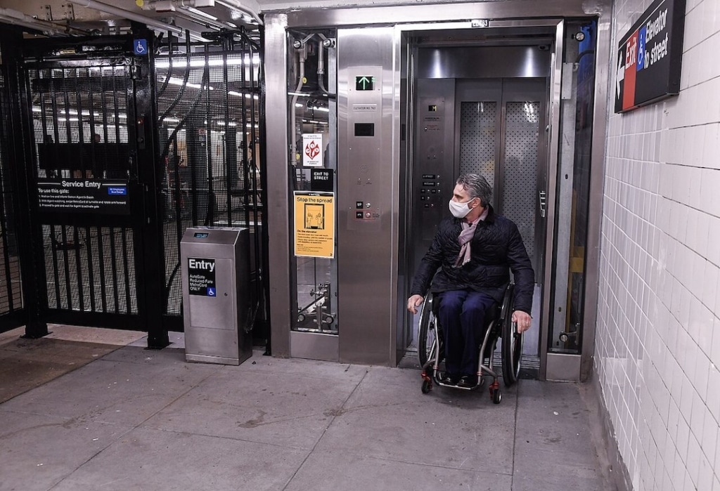 Personne en fauteuil roulant sortant d'un ascenseur dans le métro à New York