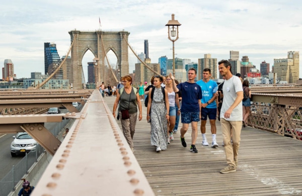 Personnes suivant une visite guidée sur le pont de Brooklyn à New York