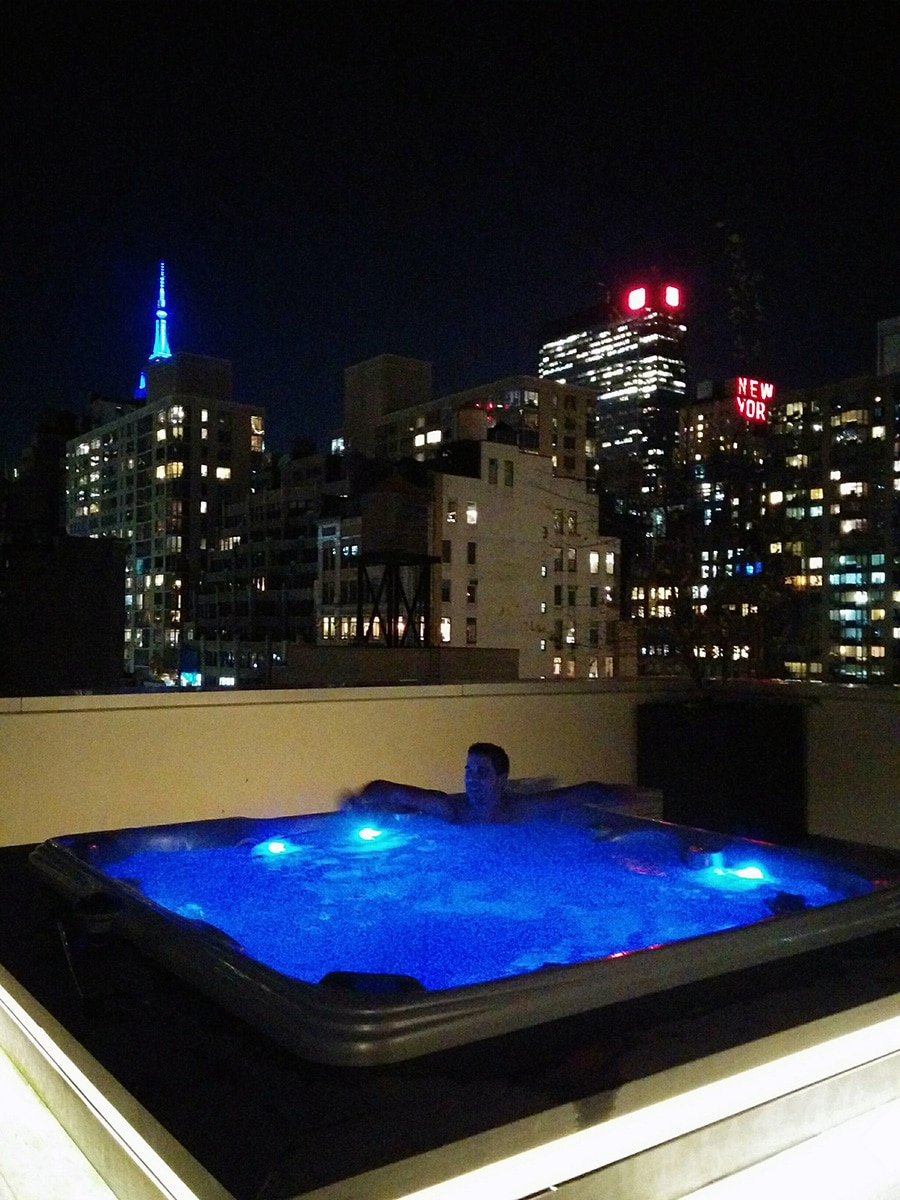 Détente dans le jacuzzi sur le rooftop de l'hôtel Cassa Times Square à New York, offrant une vue panoramique sur la ville et une expérience de relaxation ultime