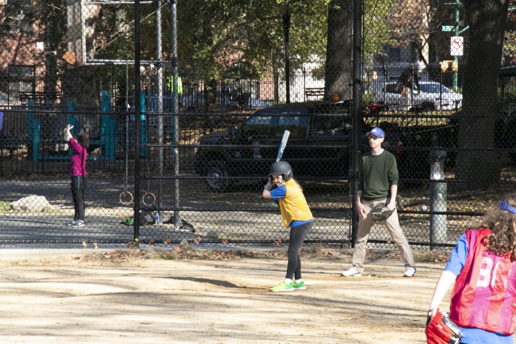 Enfant qui joue au baseball à Morningside Park.