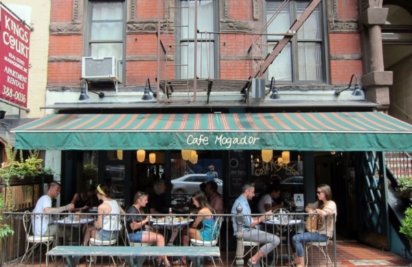 Terrasse du Café Mogador avec des personnes assises aux tables à l'extérieur
